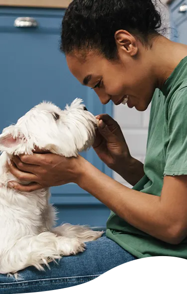A vet tech with a white dog
