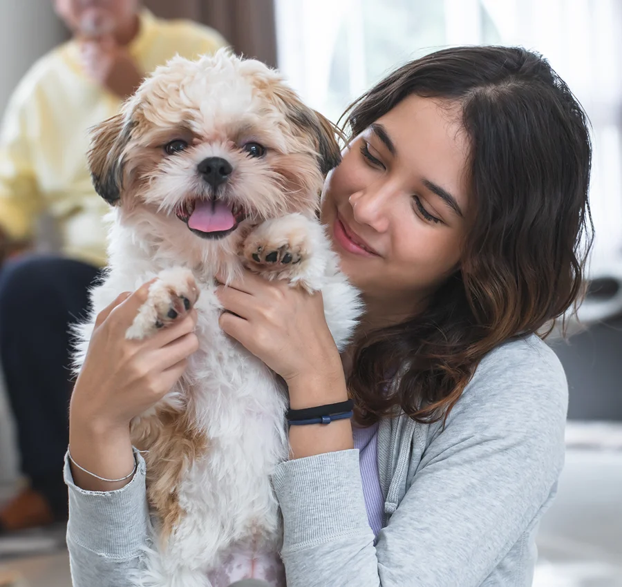 A woman hugging a little dog