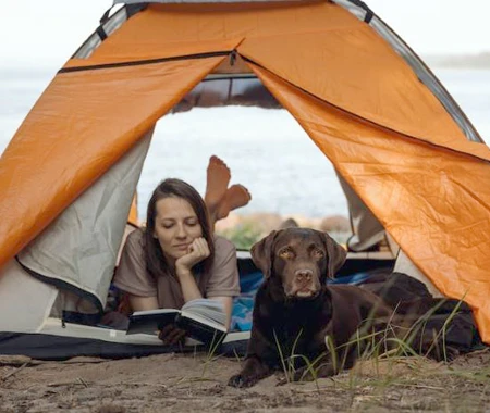 A woman with her dog inside a tent